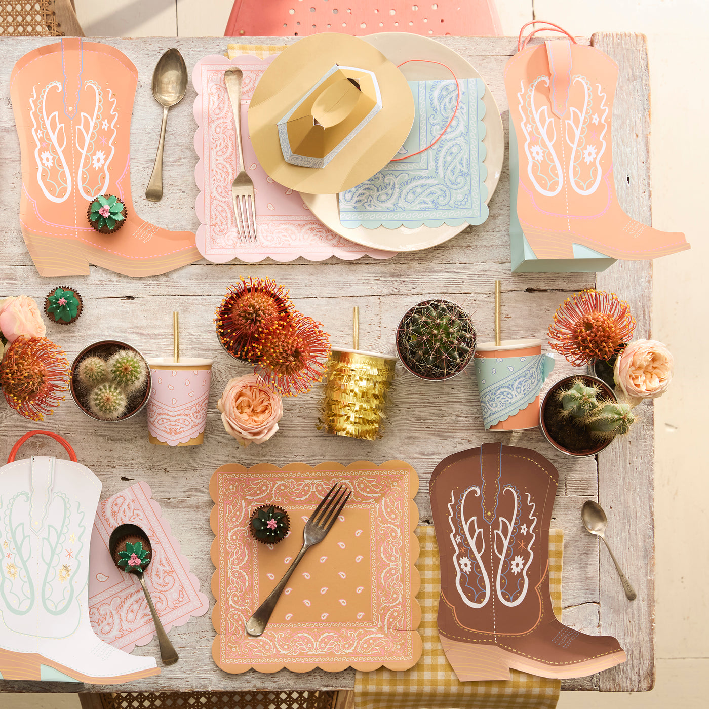 A celebratory table set with Western party plates, napkins and gift bags. 