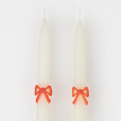 Close up of red bow on multi color bow taper candles 