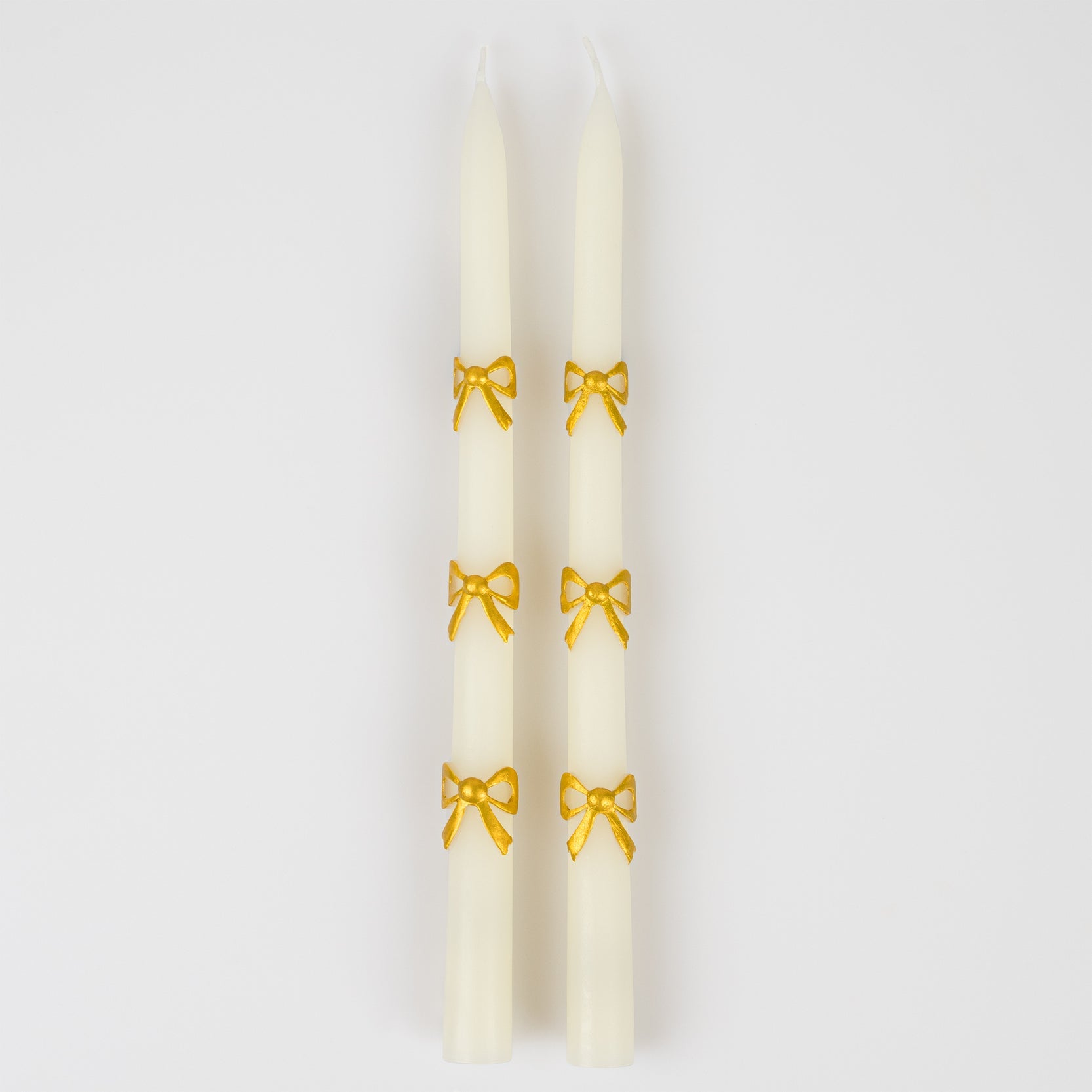 Pair of gold bow taper candles 