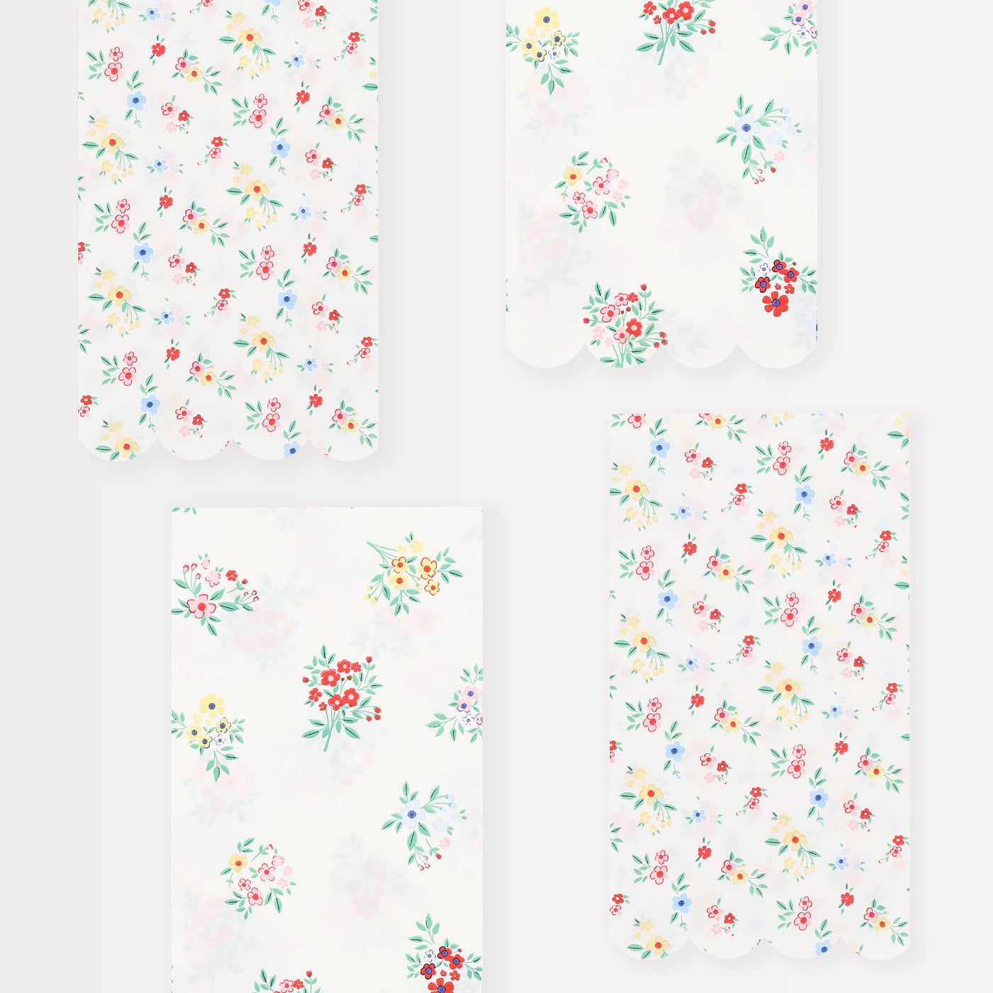 Meri Meri guest napkins with 2 different prints on them.  One a ditsy floral cluster the other has posy bouquets.  Both in assorted red, yellow, blue and pink flowers with greenery. 