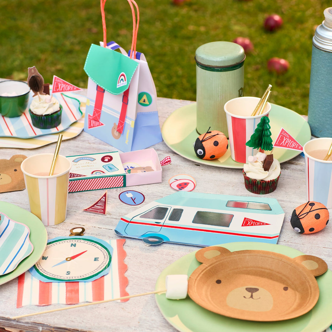 Party table set with various Meri Meri Outdoor camping paper plates, napkins and gift bags. 