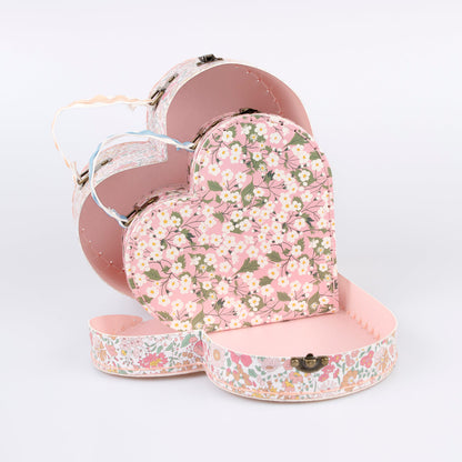 Two different sized heart-shaped suitcases made from stitched card with lamination. The smaller case can be stored inside the larger.  Each suitcase features a different Liberty floral print design, with pink tones, on the outside.