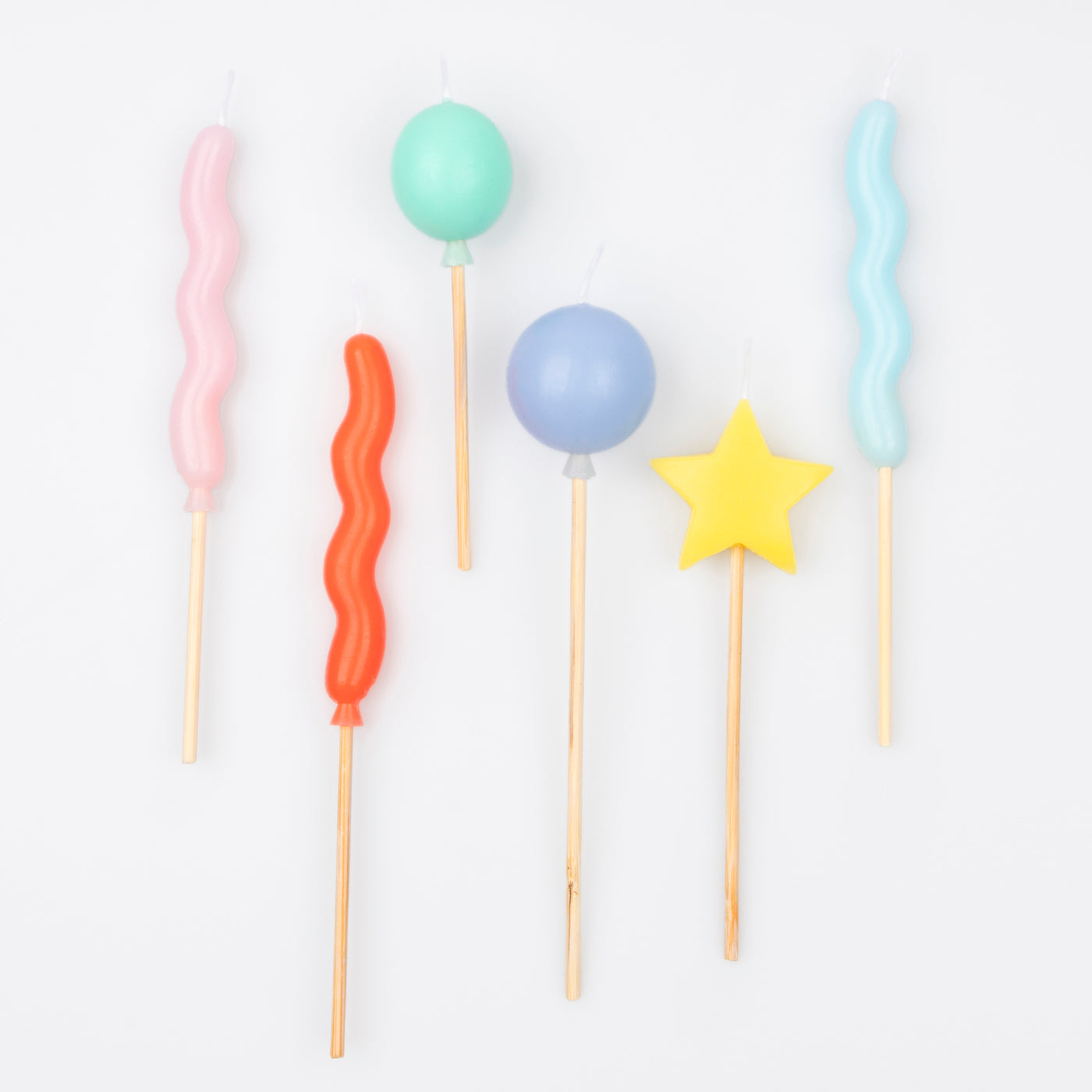 3D Moulded wax candles in 6 balloon shaped designs of 6 bright colors, including pink, bright red, mint, blue, yellow and light blue.