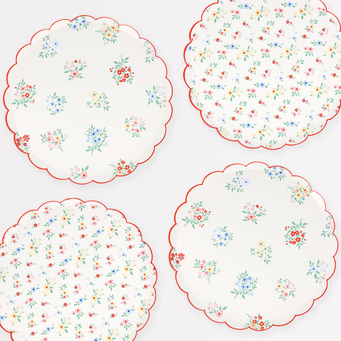 Meri Meri paper plates with two different floral patterns, ditsy clusters and posy bouquets and a scalloped red border.