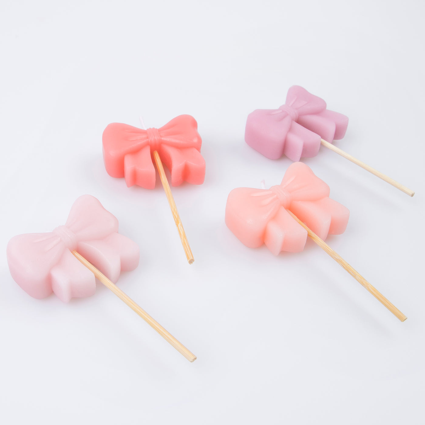 Four 3D Bow candles in shades of pink