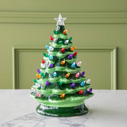 A 13&quot; Porcelain Vintage Lit Tree with Timer on a marble table.