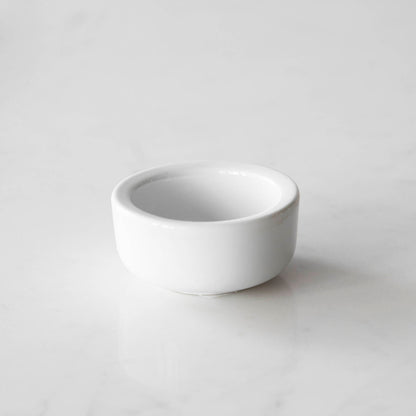 Three White Porcelain Mini Bowls with assorted spices and a spoon on a marble surface by BIA.