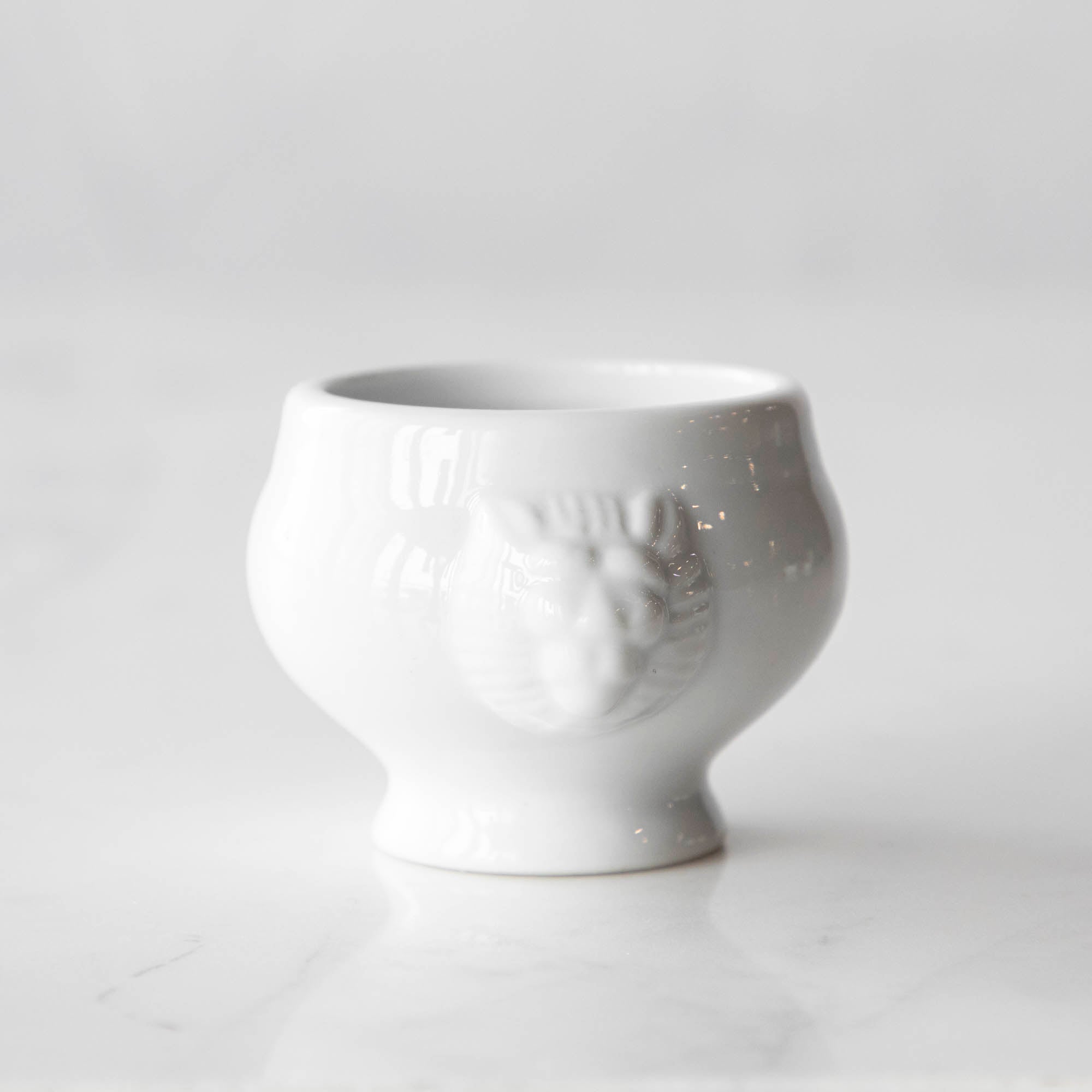 Three White Porcelain Mini Bowls with assorted spices and a spoon on a marble surface by BIA.