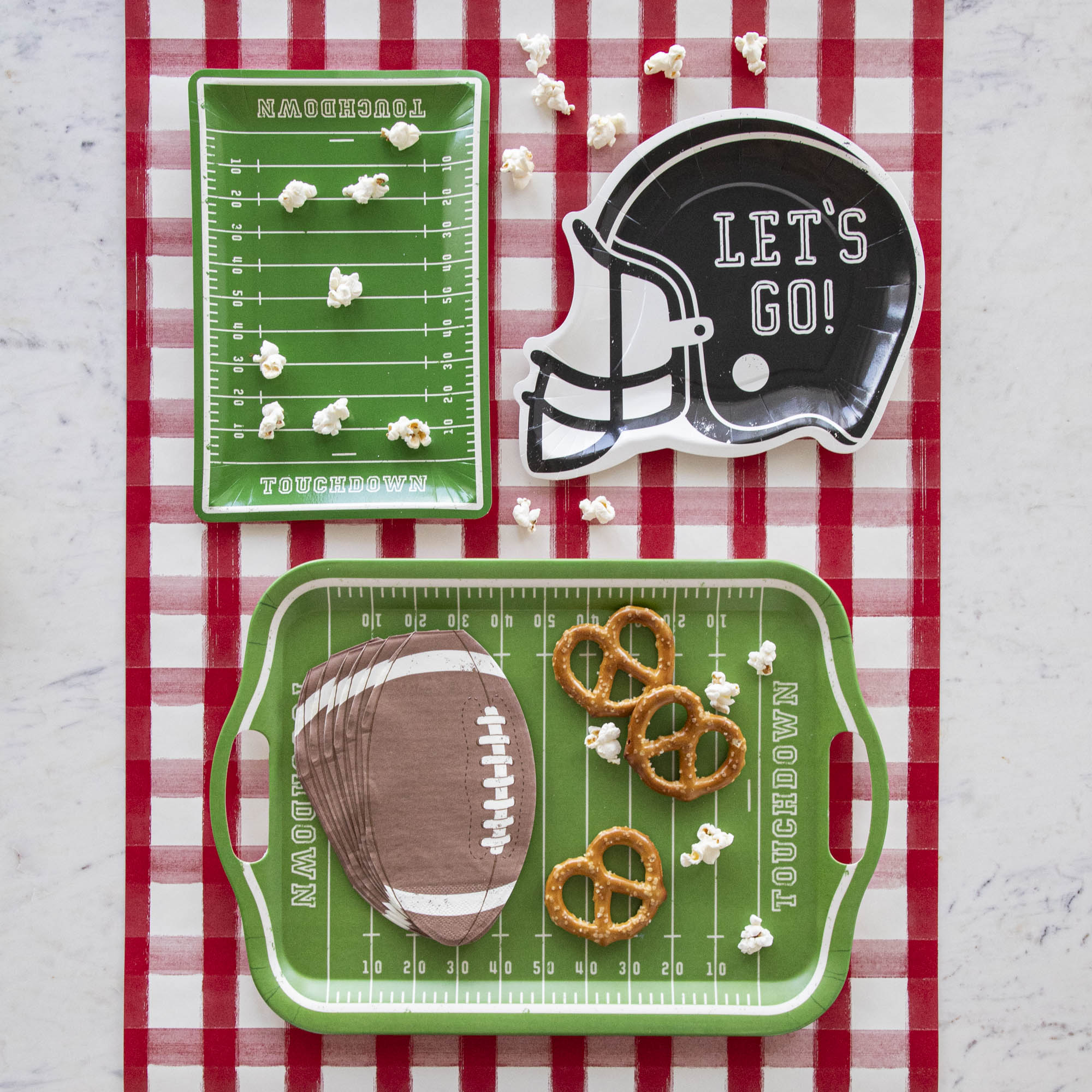 Football themed paper dinnerware with various snacks.