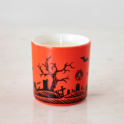 A Dracula themed candle with a red background and black silhouettes.