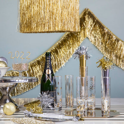 A table with a champagne bottle and glasses, adorned with Meri Meri&