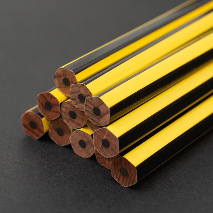 A collection of Blackwing Volume 651- Tribute to Bruce Lee pencils, one sharpened, arranged diagonally on a dark background, reminiscent of Bruce Lee&