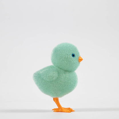 A group of colorful Glitterville felt chicks on a white plate, ready for the Easter celebration.