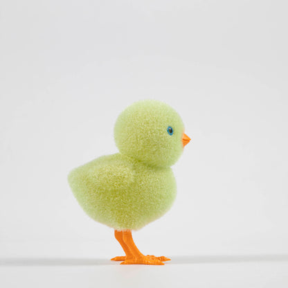 A group of colorful Glitterville felt chicks on a white plate, ready for the Easter celebration.