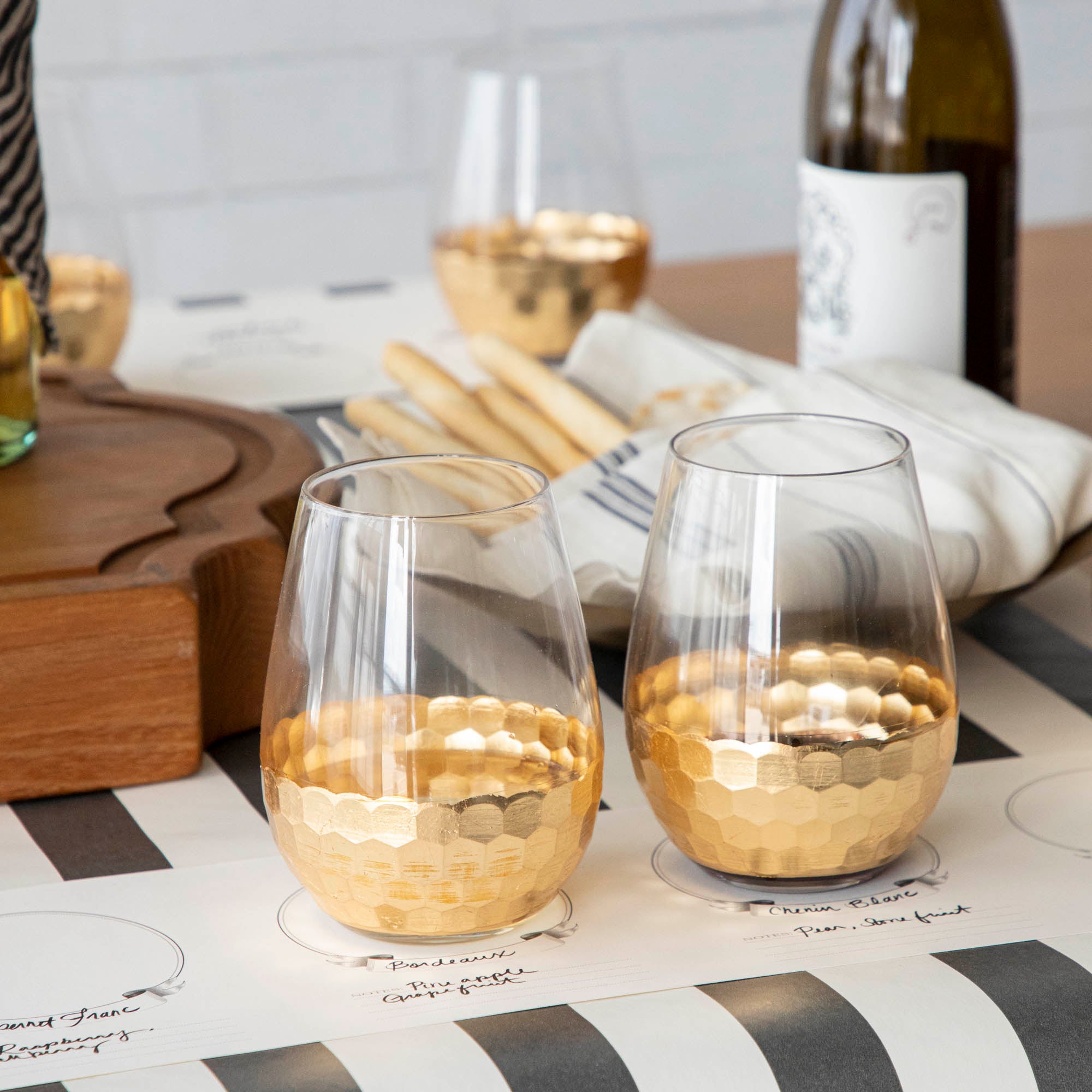 A table setting with Vitorrio Stemless Glassware plates, and napkins.