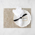 White napkin on a plate with a name card reading "Jessica" at a table setting on a glittery gold Chilewich Metallic Lace placemat.