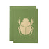 A leaf-green card with the silhouette of a scarab beetle in solid gold leaf.