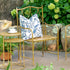 A Park Hill metal bamboo porch chair with a blue and white patterned cushion in a garden setting with a matching side table and cup.