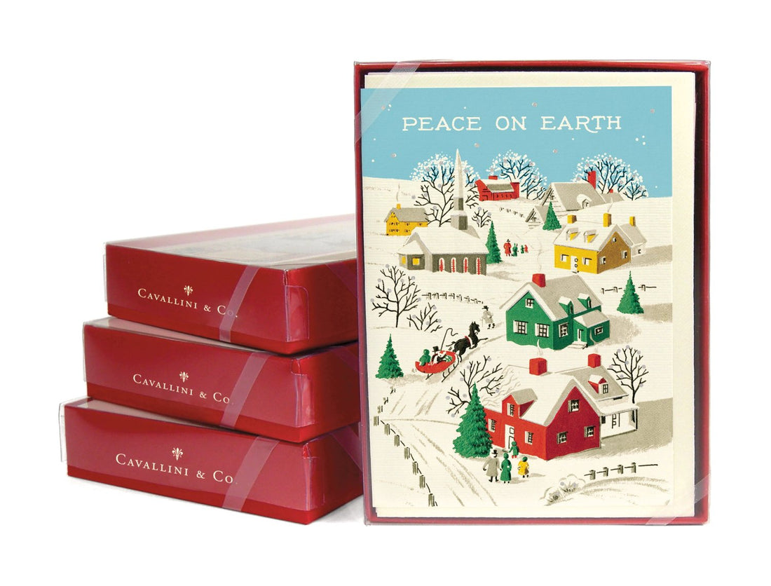 Boxed sets of cards stacked up with one facing front with image of vintage town scene saying peace on earth at the top