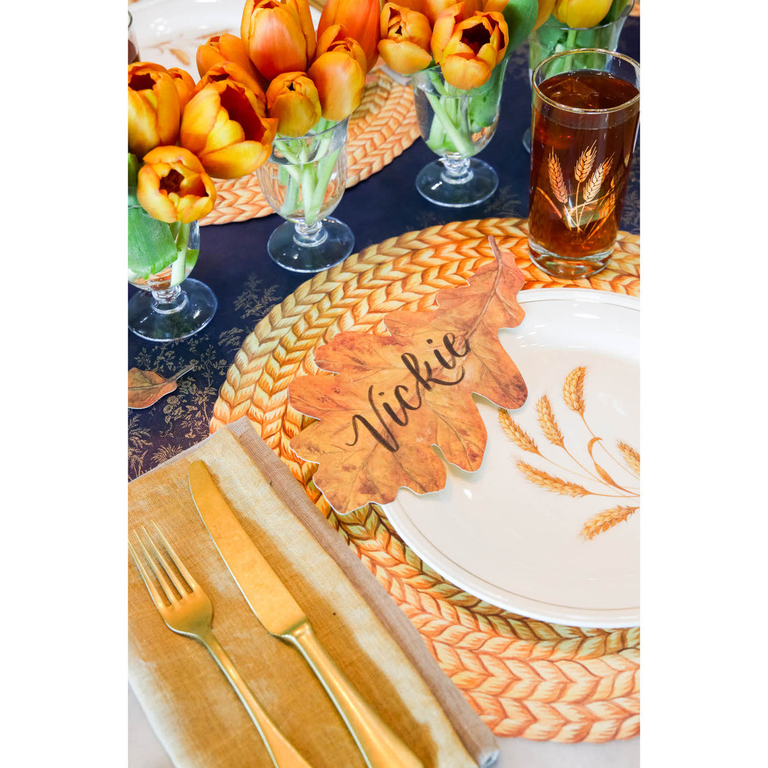 A table setting with a place setting and tulips, featuring a Die-Cut Braided Jute Placemat for added texture by Hester &amp; Cook.