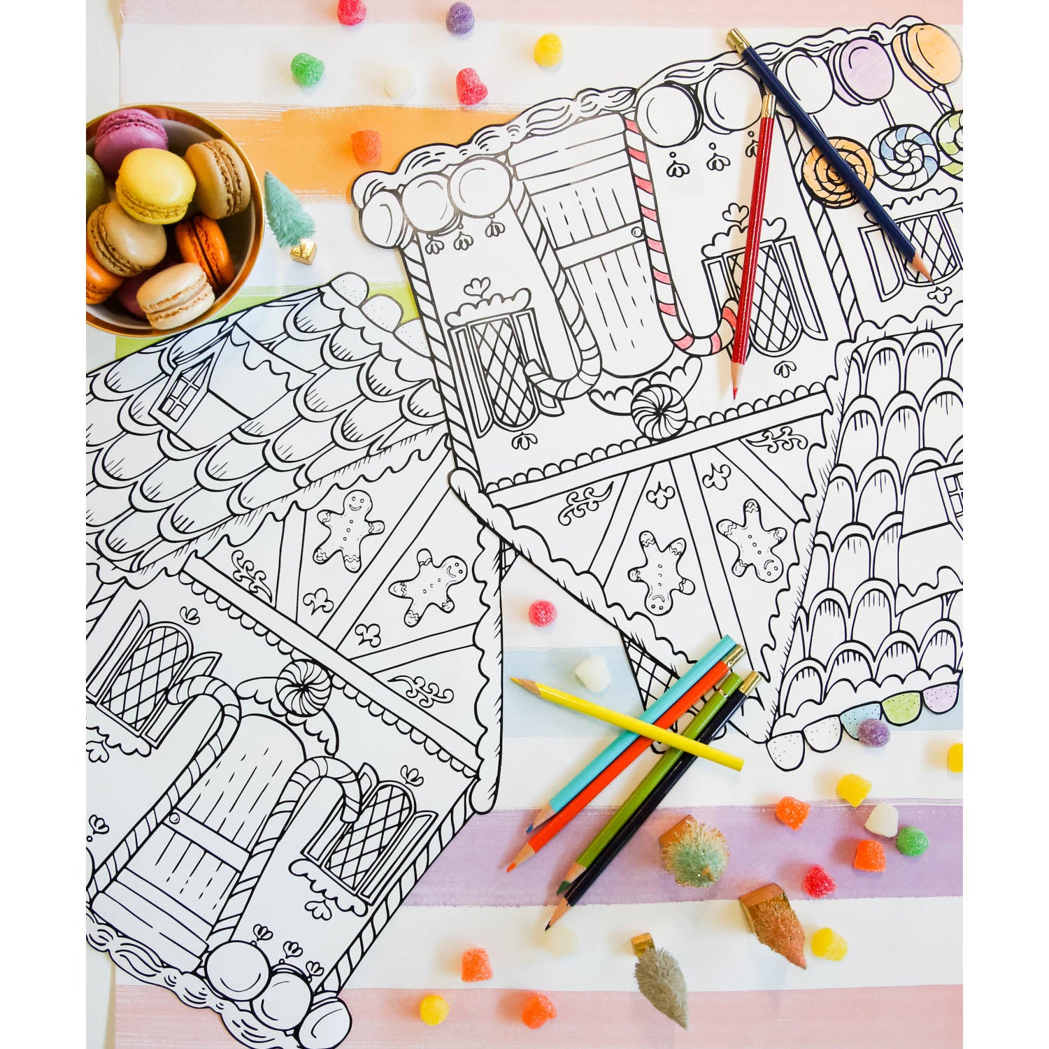 Two Die-cut Gingerbread House Coloring Placemats on a Christmas-themed activity table with colored pencils.