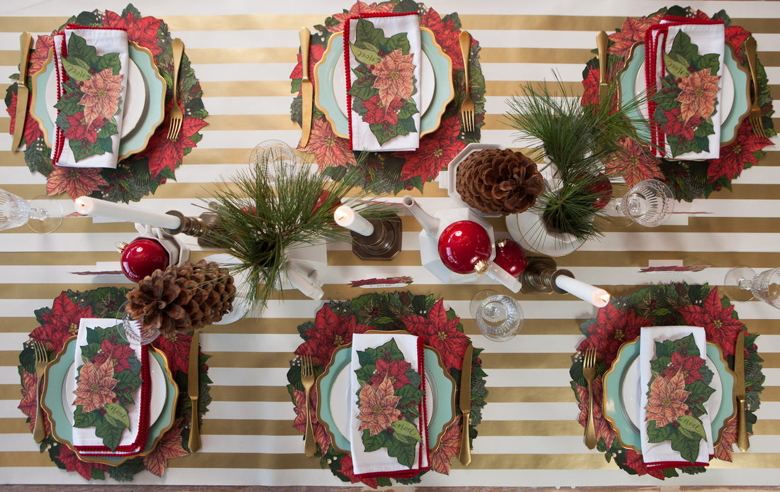 The Die-cut Poinsettia Wreath Placemat under an elegant winter-themed table setting for six, from above.