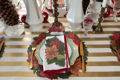 The Die-cut Poinsettia Wreath Placemat under an elegant winter-themed place setting.
