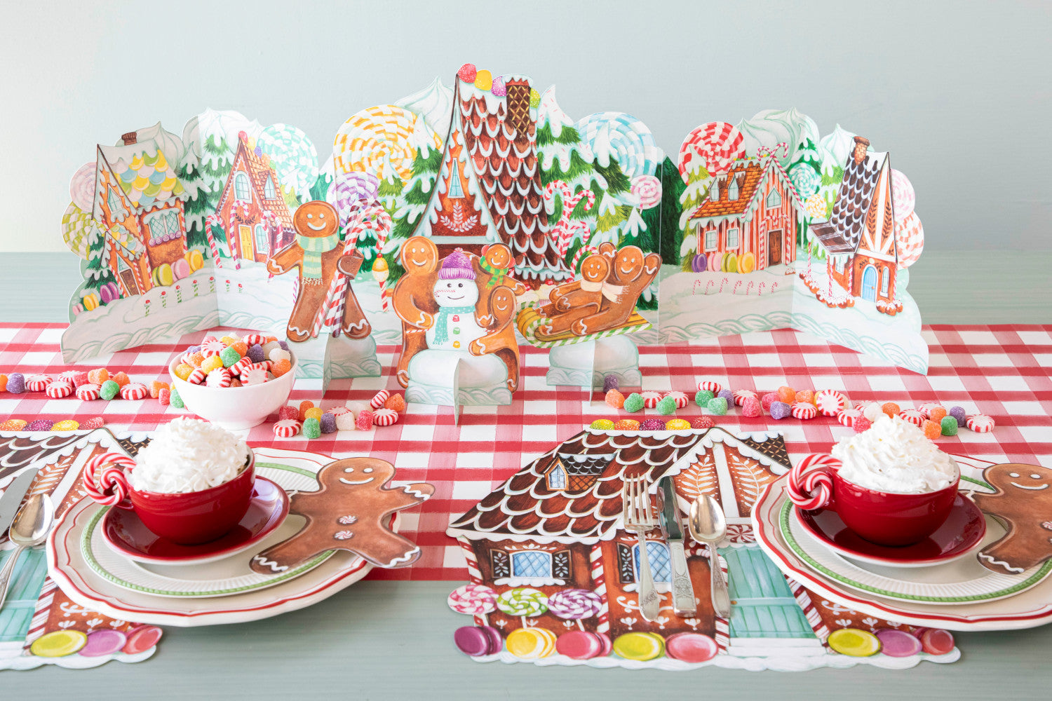 Colorful illustration of a whimsical, fantastical Gingerbread Centerscape village with intricately patterned buildings amidst lush greenery by Hester &amp; Cook.