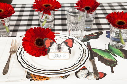 The Black Painted Check Runner under an elegant butterfly-themed place setting.