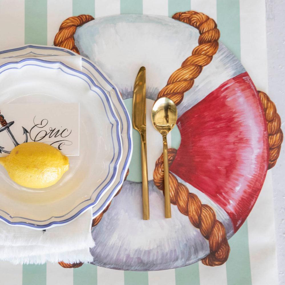 The Die-cut Life Preserver Placemat under an elegant nautical-themed place setting, from above.