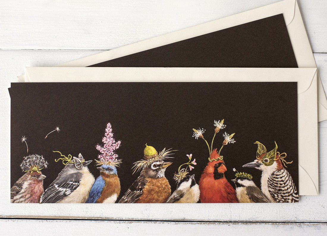 A dark brown greeting card featuring a row of songbirds wearing flowers and botanicals as hats, with the included envelope tucked behind the card. 