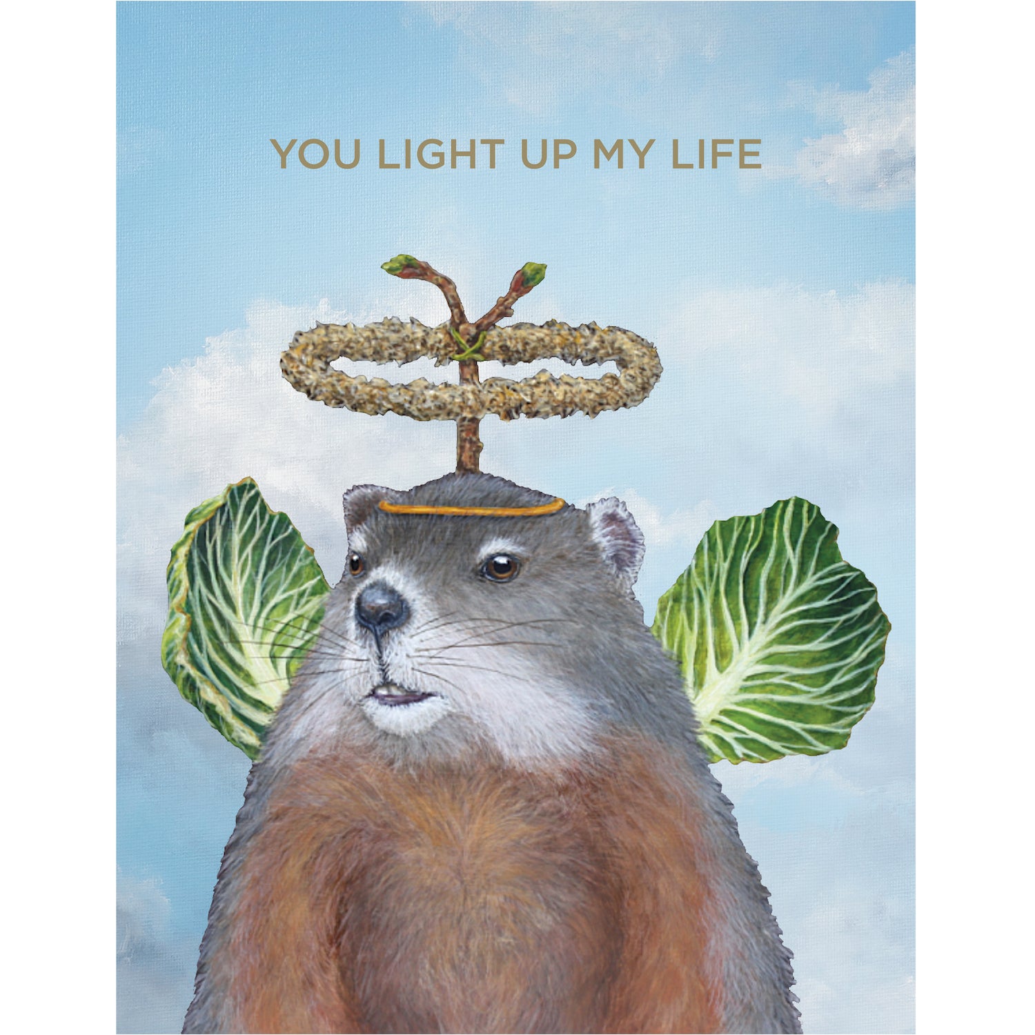 A greeting card featuring a whimsical illustration of a groundhog wearing cabbage leaf wings and a botanical halo on a cloudy sky background, with the words &quot;YOU LIGHT UP MY LIFE&quot; printed in gold. 