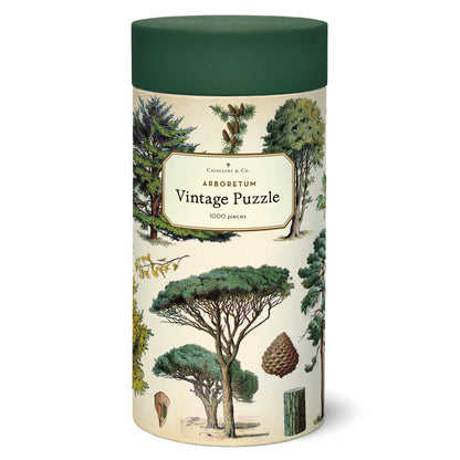 A 1000-piece Arboretum Puzzle featuring arboretum-themed vintage illustrations, packaged in a cylindrical container by Cavallini Papers &amp; Co.