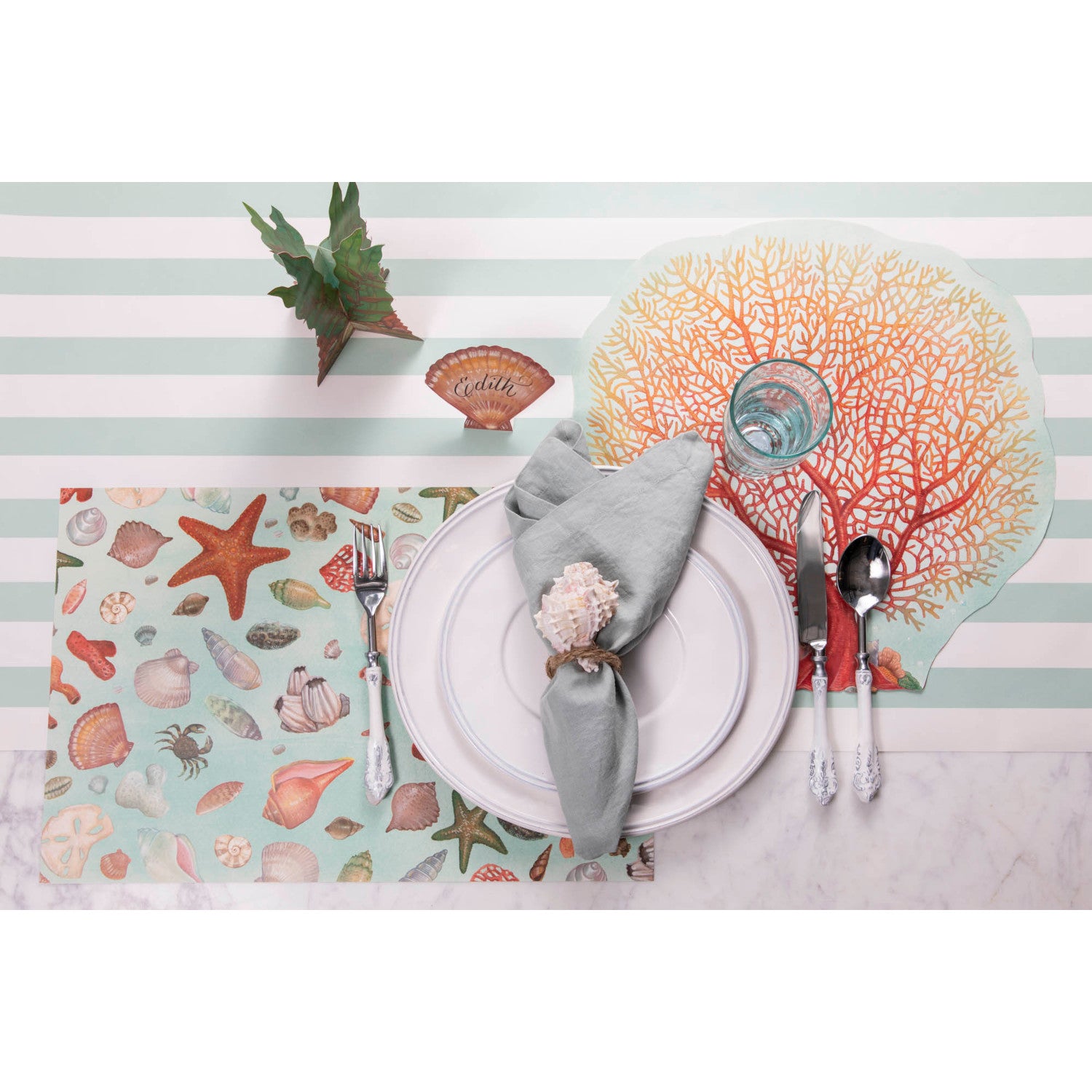 The Die-cut Coral Placemat under an elegant beach-themed place setting, from above.