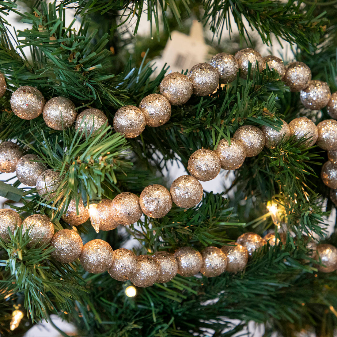 Glitter Ball Champagne garland draped on a lighted tree.