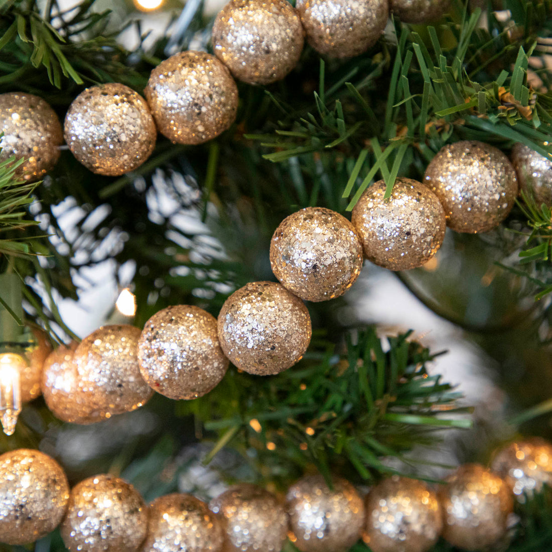 A closeup of the Glitter Ball Champagne Garland showing its glittery details.