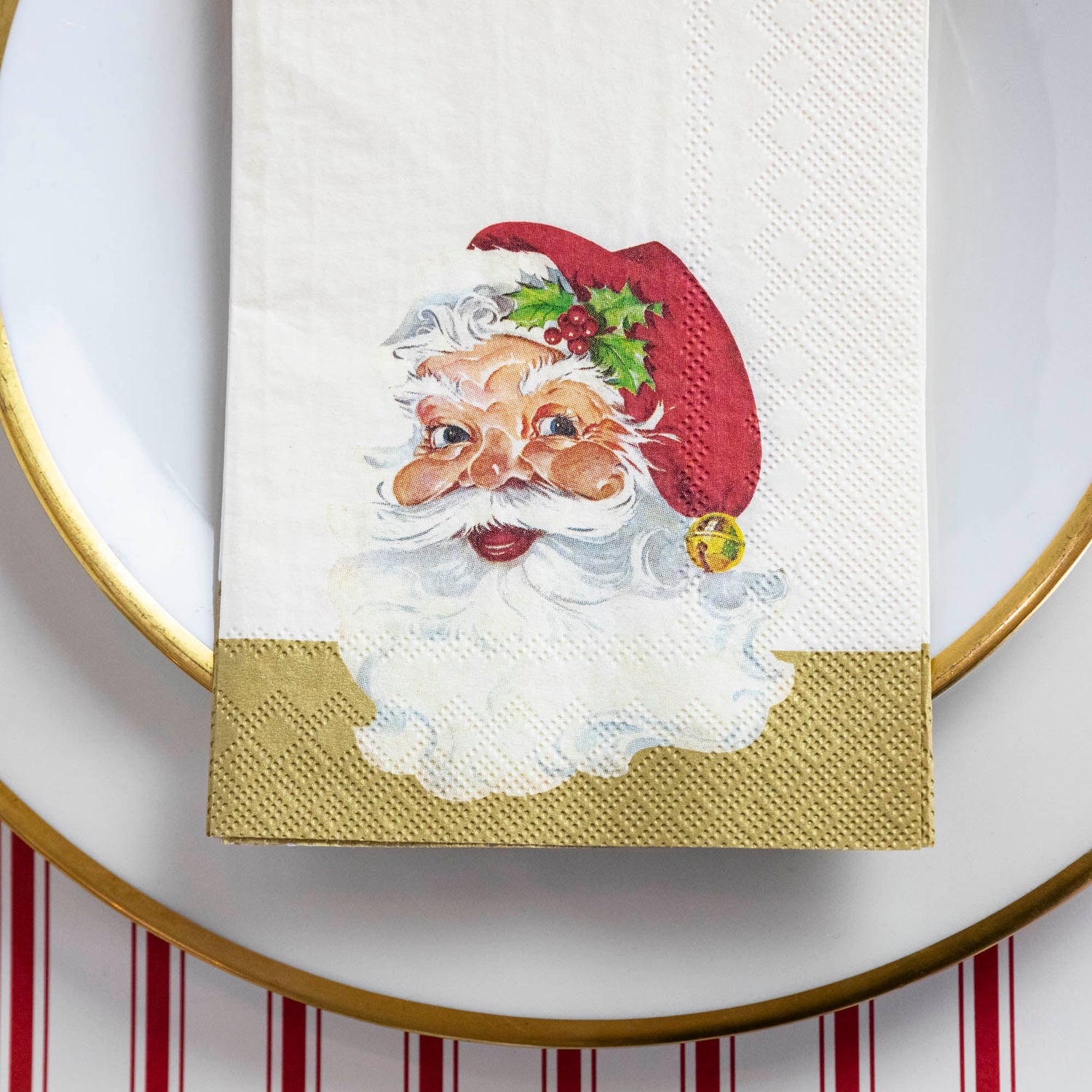 Close-up of a Santa Guest Napkin centered on a plate in a Christmas place setting.