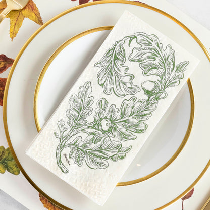 An Oak Leaves Guest Napkin centered on a gold-rimmed white plate in a rustic place setting.