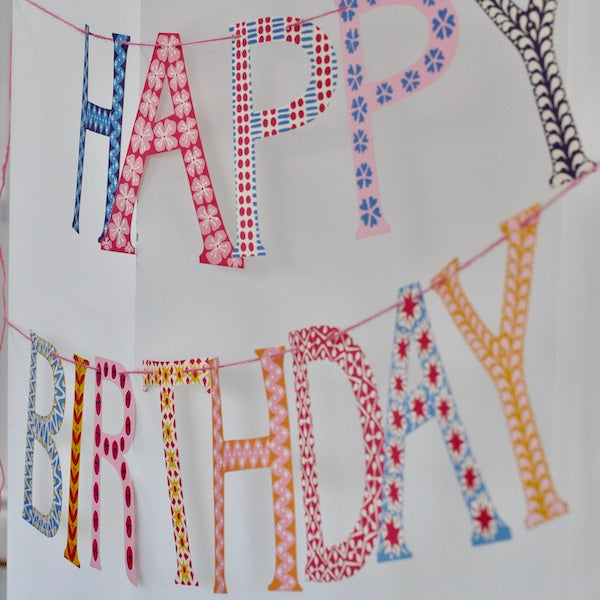 A Cambridge Imprint birthday banner hanging on a wall.