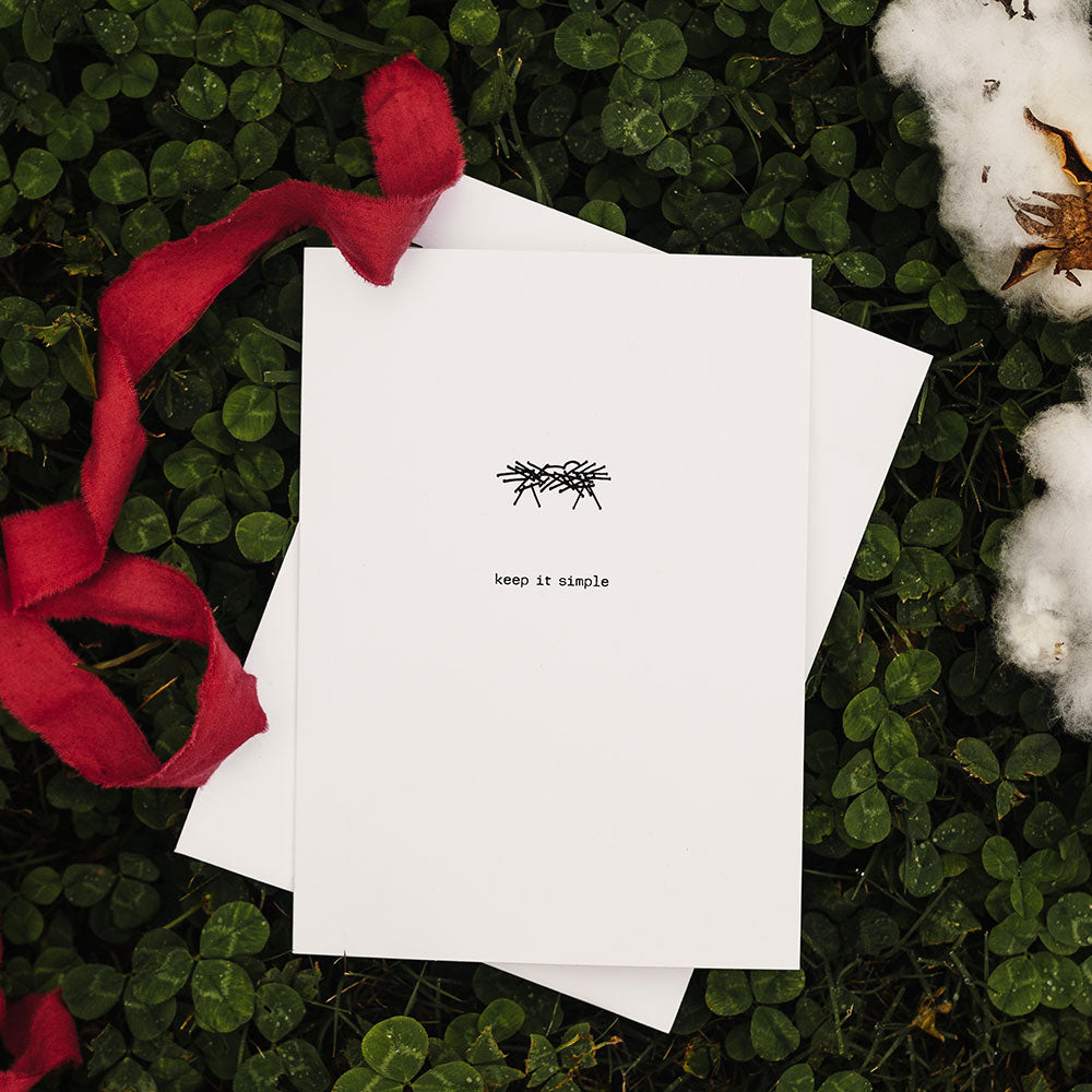 A Keep It Simple - Merry Christmas Notecard by David Arms, with a handwritten note and an illustration, surrounded by greenery and a red ribbon.