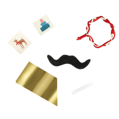 a gold foil party hat, a joke, 2 stickers (one foiled), a mint, red and white friendship bracelet, and a black self adhesive mustache