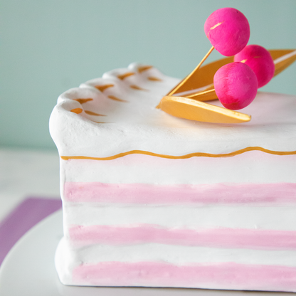 A stack of plates with Glitterville Large French Cake Slices with Gold Leaf on them for a party.